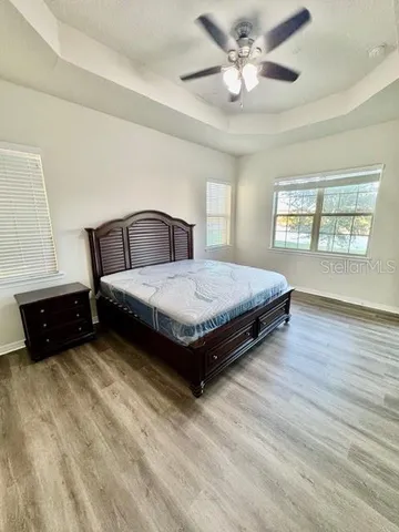 a spacious bedroom with a bed and a chandelier