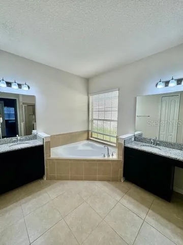 a spacious bathroom with a bathtub sink and mirror