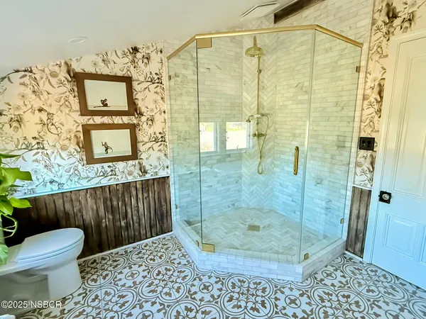 a bathroom with a toilet and a shower