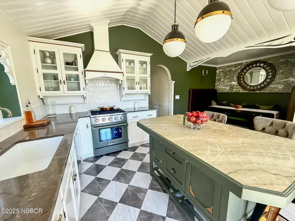 a kitchen with stainless steel appliances granite countertop a stove a sink and a chandelier