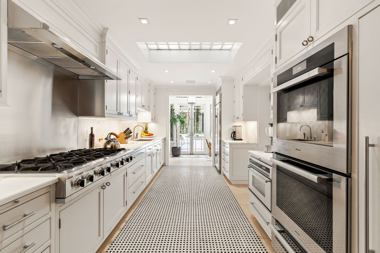 116 East 70th Street Manhattan, NY 10021 - Photo 4 of 22 a large kitchen with stainless steel appliances granite countertop a stove and a sink