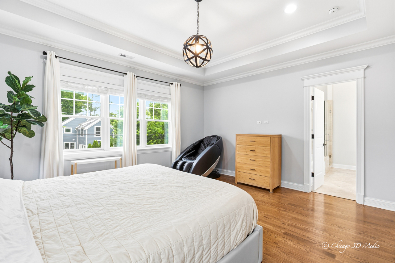 306 17th Street Wilmette, IL 60091 - Photo 25 of 48 a bedroom with a bed a window and a chandelier