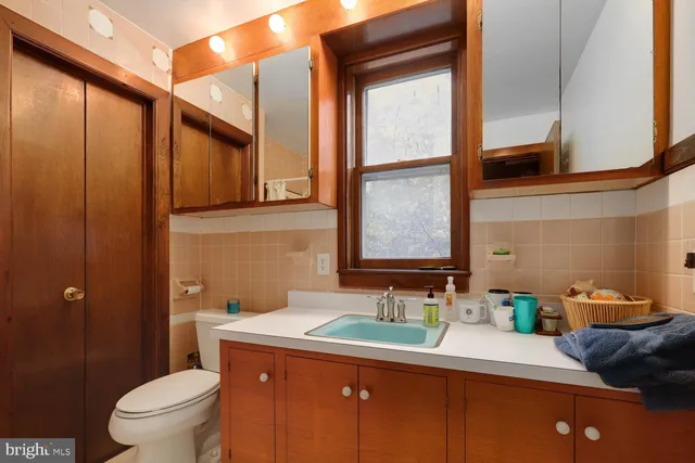 a bathroom with a granite countertop sink toilet and mirror