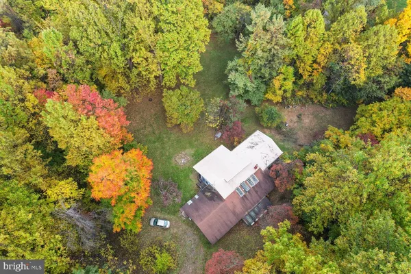 an aerial view of a house with swimming pool and lawn chairs