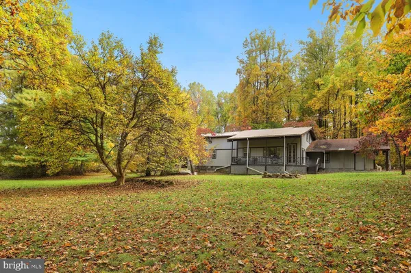 a view of a house with a big yard and large trees