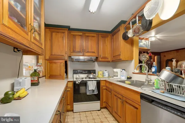 a kitchen with kitchen island granite countertop a sink a counter space appliances and cabinets