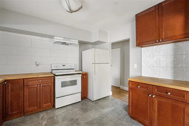 a kitchen with stainless steel appliances granite countertop a refrigerator and cabinets