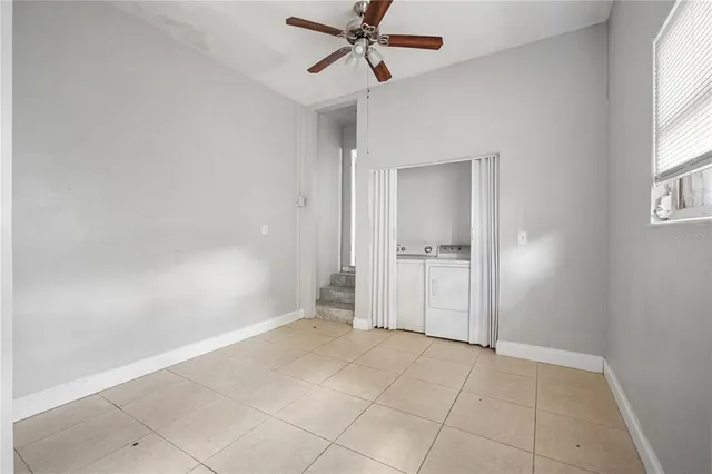 an empty room with a bathroom and windows