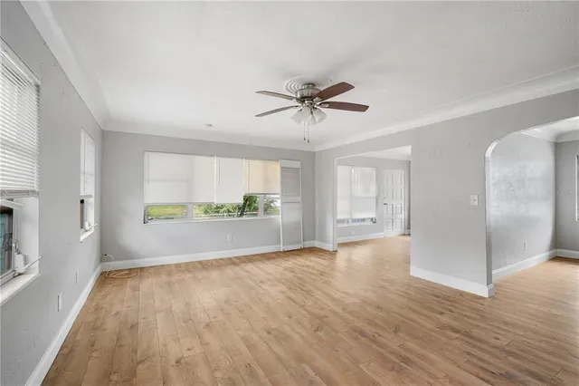 a view of room with window ceiling fan and hardwood floor