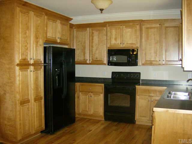 135 Piney Forest Road Roxboro, NC 27574 - Photo 3 of 10 a kitchen with a refrigerator stove and cabinets