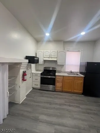 a kitchen with granite countertop white cabinets and stainless steel appliances