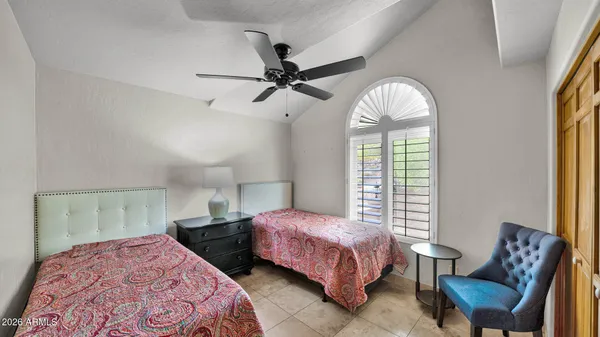 a bedroom with a bed mirror and window