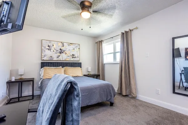 a bedroom with a bed and a painting on the wall