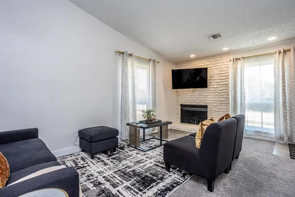 a living room with furniture a flat screen tv and a fireplace