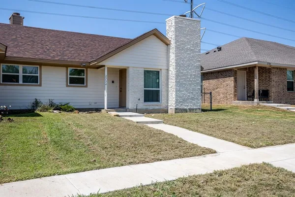 a view of a brick house with wooden fence