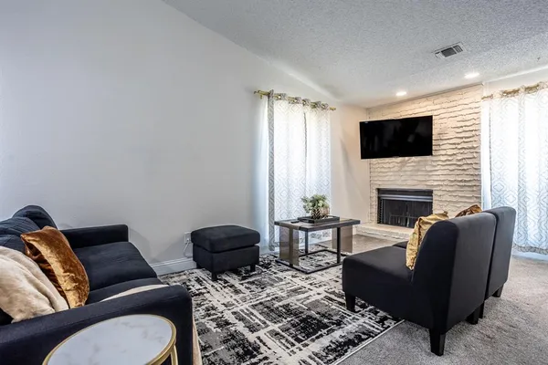 a living room with furniture a flat screen tv and a fireplace