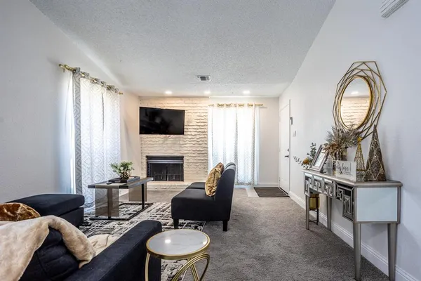 a living room with furniture a fireplace and a flat screen tv