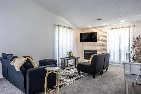 a living room with furniture a fireplace and a flat screen tv