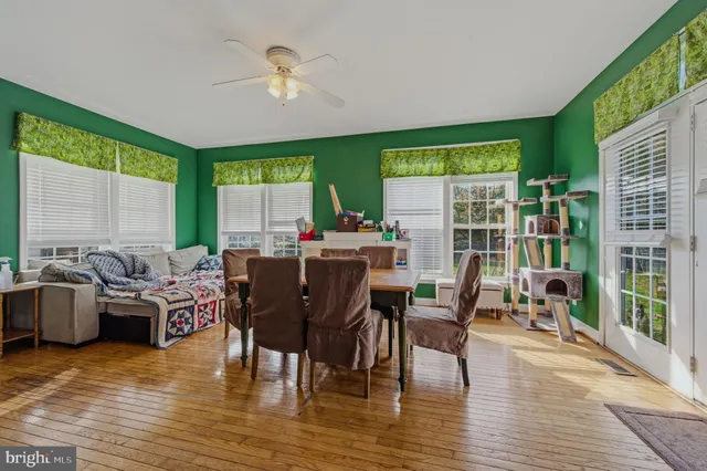 a kitchen with stainless steel appliances granite countertop a refrigerator a stove top oven a sink dishwasher and white cabinets with wooden floor