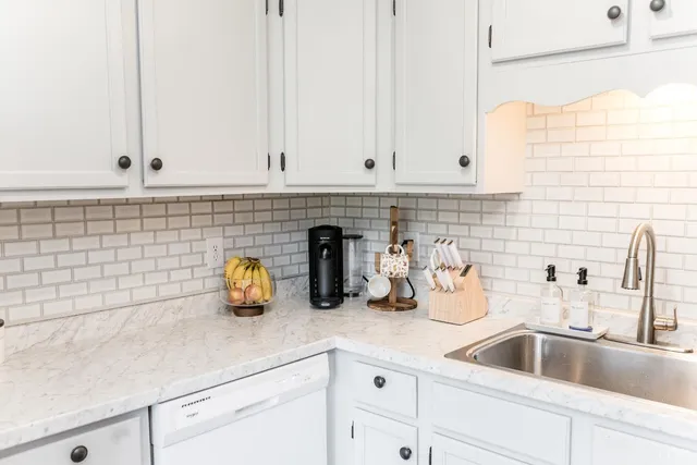 a kitchen with granite countertop white cabinets and white appliances
