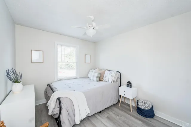 a bedroom with a white bed and a ceiling fan