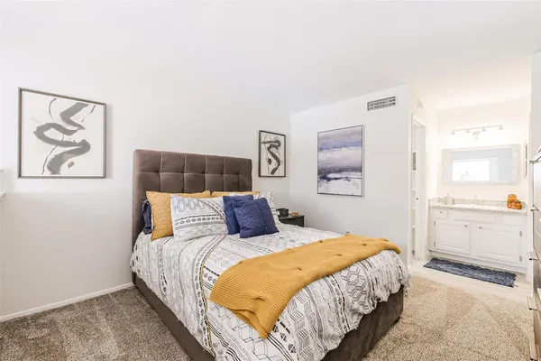 a bedroom with a bed and lamp