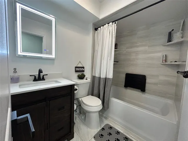 a bathroom with a sink a toilet a mirror and shower