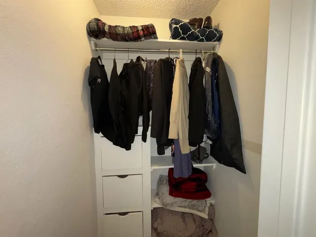 a view of walk in closet with clothes and shoes