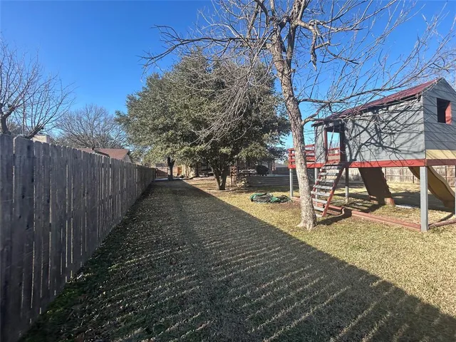 a view of a backyard with wooden fence