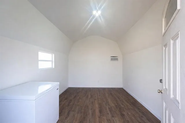 an empty room with a hardwood and a window