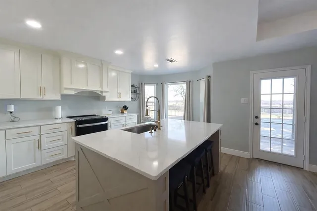 a kitchen with sink cabinets and wooden floor