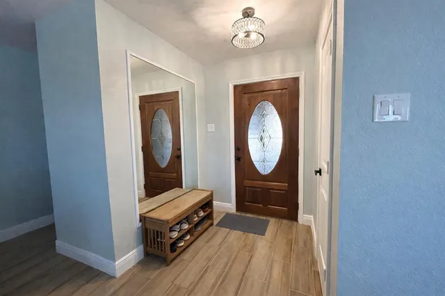 a room with wooden floor a mirror and a wooden floor