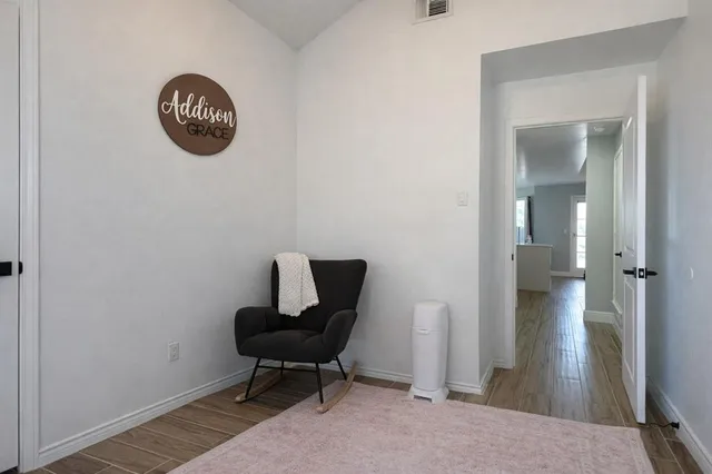 a view of a livingroom with a chair and wooden floor