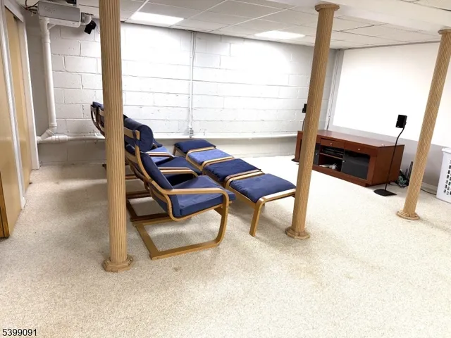 a living room with furniture a flat screen tv and a window