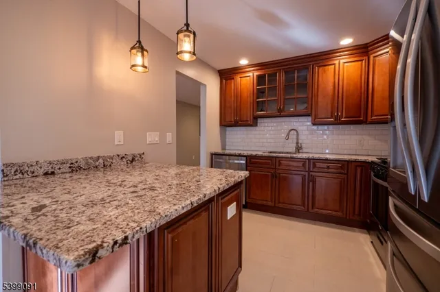 a kitchen with stainless steel appliances granite countertop a sink stove and cabinets