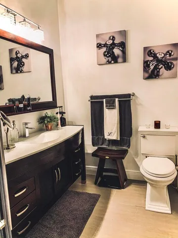 a bathroom with a toilet a sink and mirror