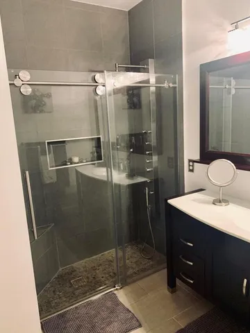 a bathroom with a shower sink and mirror