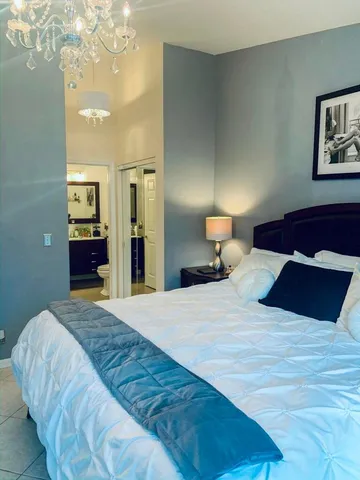 a bedroom with a bed and a chandelier