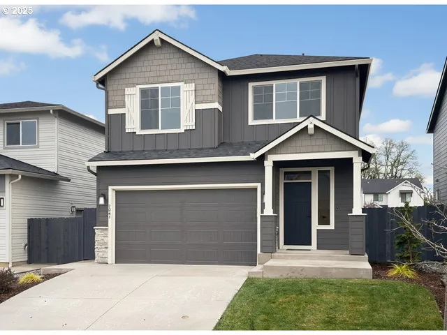 a front view of a house with yard and parking