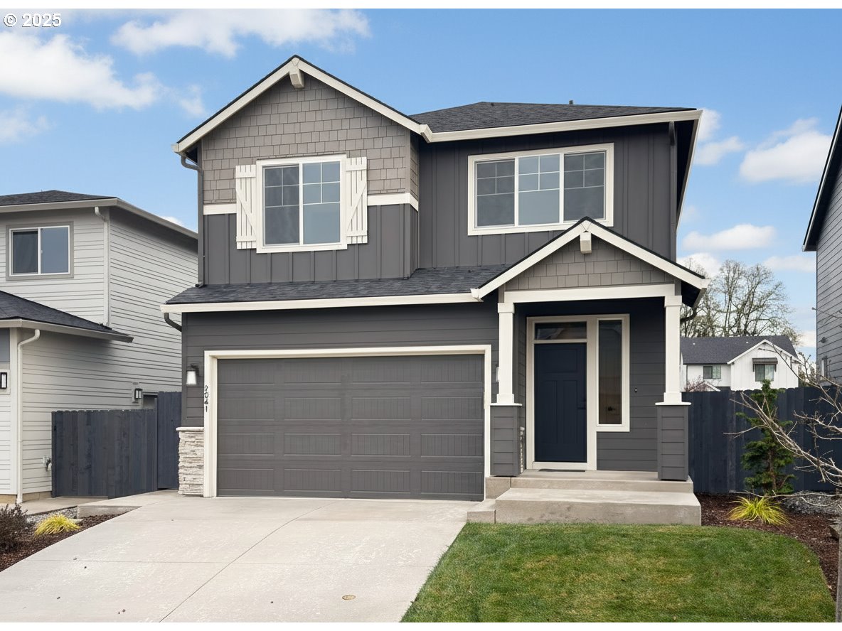 a front view of a house with yard and parking