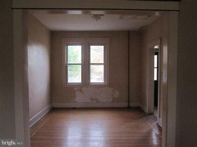 353 Marydell Road Baltimore, MD 21229 - Photo 6 of 20 a view of an empty room with wooden floor and a window