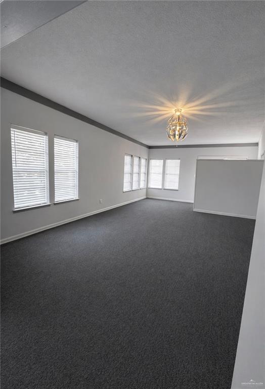 1403 North Shary Road Mission, TX 78572 - Photo 2 of 9 Empty room featuring dark carpet and a textured ceiling