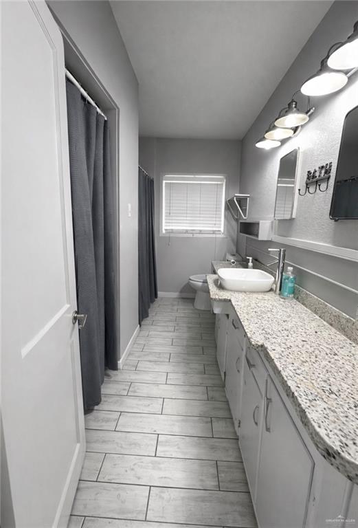 1403 North Shary Road Mission, TX 78572 - Photo 6 of 9 Bathroom with vanity, curtained shower, and wood tiled floors