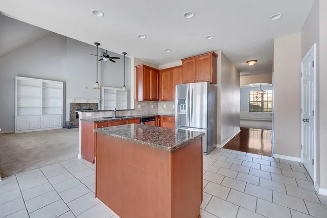 a kitchen with stainless steel appliances granite countertop a refrigerator a oven and a sink