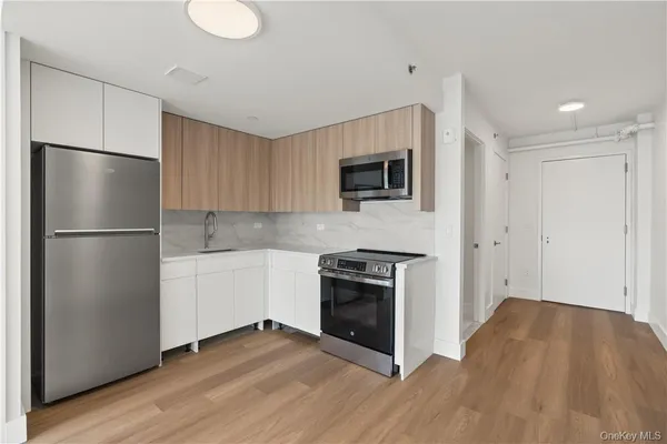 a kitchen with a refrigerator and a stove top oven