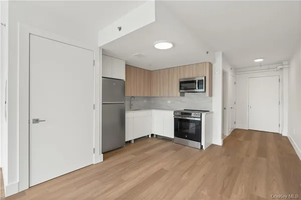 a kitchen with a refrigerator and a stove top oven