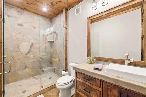 a bathroom with a sink toilet a mirror and shower