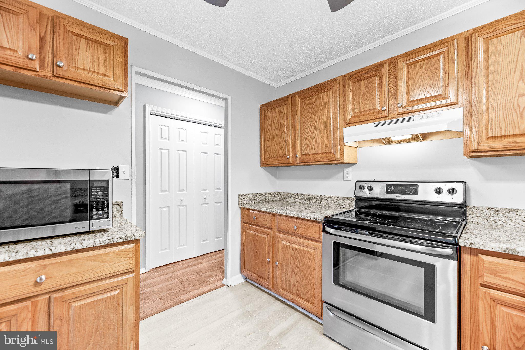 11951 Prince Court Dunkirk, MD 20754 - Photo 13 of 72 a kitchen with granite countertop a stove microwave and cabinets
