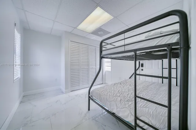 a view of a hallway with wooden floor and a bathroom