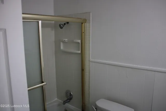 a bathroom with a toilet and a shower